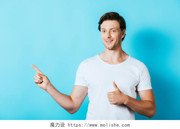 身穿白色T恤的年轻人用手指指指着在蓝色背景上摆出一副手势的样子男士头发